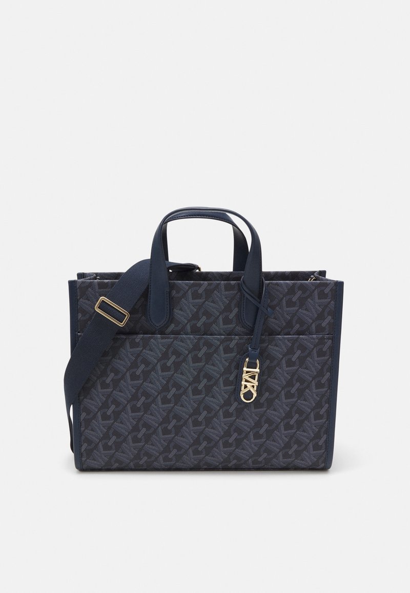 Námořnická taška z látky s reliéfním vzorem loga, dvojitými horními uchy a odnímatelným ramenním popruhem s akcenty ze zlaceného kovu.