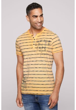 Yellow striped T-shirt with short sleeves, featuring blue horizontal lines and graphic text. Soft texture, buttoned neckline, and casual fit.