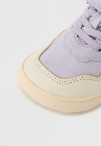 Αθλητικό παπούτσι με πάνω μέρος από σουέντ σε λιλά απόχρωση, κρεμ λεπτομέρειες από δέρμα και υφασμένη σόλα από καουτσούκ. Διαθέτει ραμμένες διακοσμήσεις και κορδόνια σε ταιριαστό χρώμα.