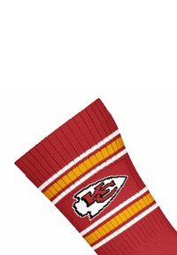 Rote Socke mit geripptem Textur, versehen mit gelben und weißen Streifen und einem weißen Logo mit rotem "KC" an der Seite.