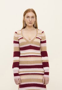 Rochie tricotată cu decolteu adânc în V și mâneci lungi, având dungi orizontale în nuanțe de bordo, bej, roz și galben pal. Material texturat.