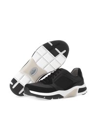 Zwarte sportieve schoenen met een gestructureerde bovenkant en mesh-paneel, met een witte tussenzool en een gripvaste rubberen zool met onderscheidende groeven.