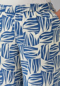 Blauwe en witte shorts met een bladpatroon. Gemaakt van zachte stof met een elastische tailleband en een relaxte pasvorm.