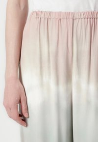 Lightweight, elastic waist trousers showcasing a gradient pattern from soft pink to pale green, with a smooth, flowing texture.