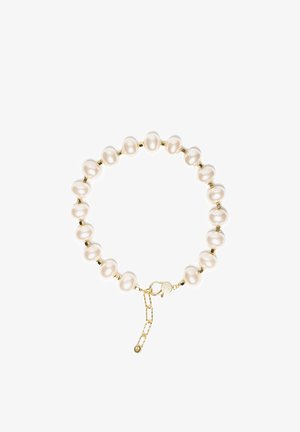 Bransoletka z owalnymi białymi perłami, rozdzielonymi małymi złotymi koralikami, wykończona złotym zapięciem typu karabińczyk i regulowanym łańcuszkiem.