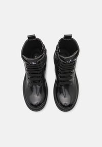 Černé lakované kožené kotníkové boty s šněrováním, strukturovaný design a hladký povrch. Obsahují zip a detail loga na jazyku.