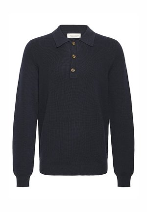 Marineblå strikket polotrøje med lange ærmer, klassisk krave, fireknapslukning og ribstrikkede manchetter. Strukturstrik med et subtilt mønster.