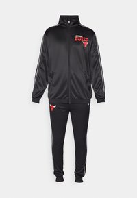 Black tracksuit made of shiny fabric featuring a zip-up jacket with red Chicago Bulls logo and pants with similar logo and white stripes.