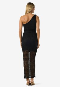 Mustast pitsist kleit ühele õlale, vormitud ülakeha, läbipaistev tagakülg ja tekstuuriga kangas. Pikk, peen siluett seljataguse lõhikuga.