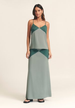 Two-piece outfit featuring a sleeveless top and long skirt in blended green shades. The fabric is smooth with a geometric pattern on the bodice.