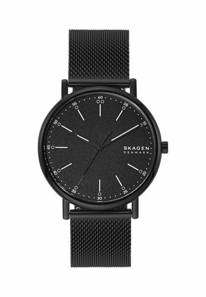 Schwarze Skagen-Armbanduhr mit minimalistischem Zifferblatt, weißen Stundenmarkierungen, drei Zeigern und schwarzem Mesh-Armband. Die Uhrzeit zeigt 10:09:35 an.