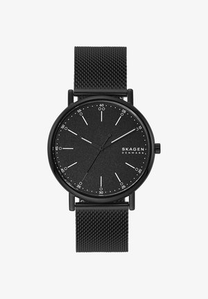 Schwarze Skagen-Armbanduhr mit minimalistischem Zifferblatt, weißen Stundenmarkierungen, drei Zeigern und schwarzem Mesh-Armband. Die Uhrzeit zeigt 10:09:35 an.
