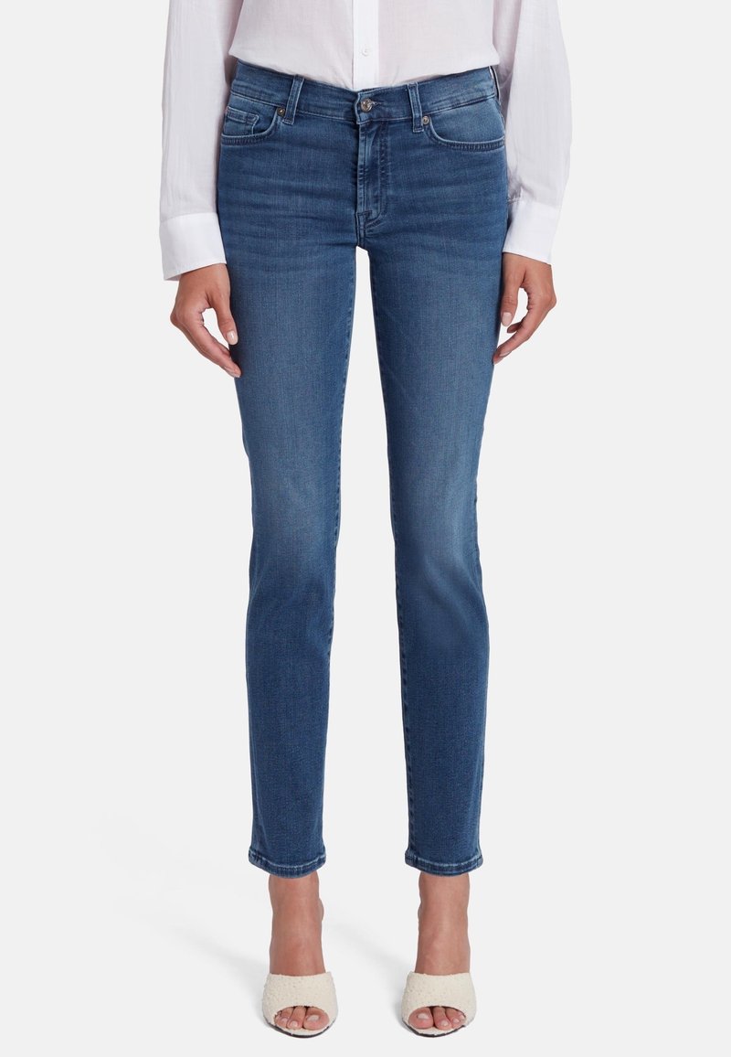 Jeans in denim blu con una vestibilità slim, vita media e leggere sfumature sulle cosce. Presentano cinque tasche e una chiusura a bottone classica.