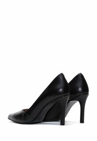 Black leather high-heeled shoes with a pointed toe design and a smooth texture, featuring slim, curved heels and minimalistic detailing.
