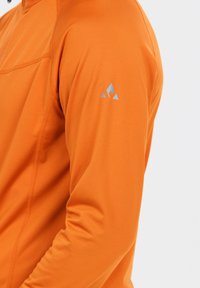 Oranges langärmliges Oberteil aus glattem Stoff. Verfügt über ein hellblaues Logo auf der Schulter und sichtbare Nähdetails.