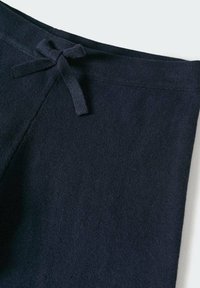 Pantalones de algodón azul marino con una textura suave, con cintura ajustable y detalles de costura mínimos.