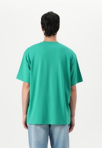 Guess Jeans TEE - Nyomott mintás póló - green leafs