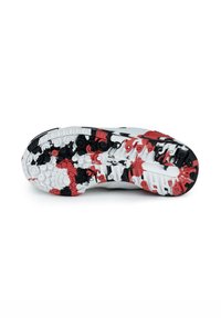 Suela de zapato con una mezcla de colores blanco, negro y rojo. Presenta patrones de tracción distintos, tacos multidireccionales y una superficie texturizada.