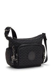Black fabric crossbody bag with a textured diamond pattern, adjustable strap, two zippered compartments, and a decorative metal charm.