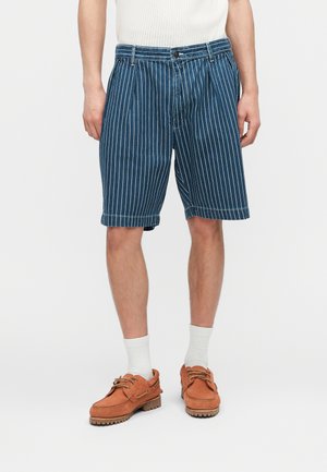 Herren-Blaue-Knielange-Shorts mit Nadelstreifen, getragen mit weißen Socken und braunen Schnürschuhen, gezeigt von der Taille bis zu den Füßen.