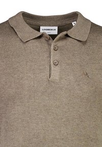 Polo de punto marrón con tres botones marrones, cuello acanalado y logotipo bordado en el lado izquierdo. Diseño ajustado, textura suave.