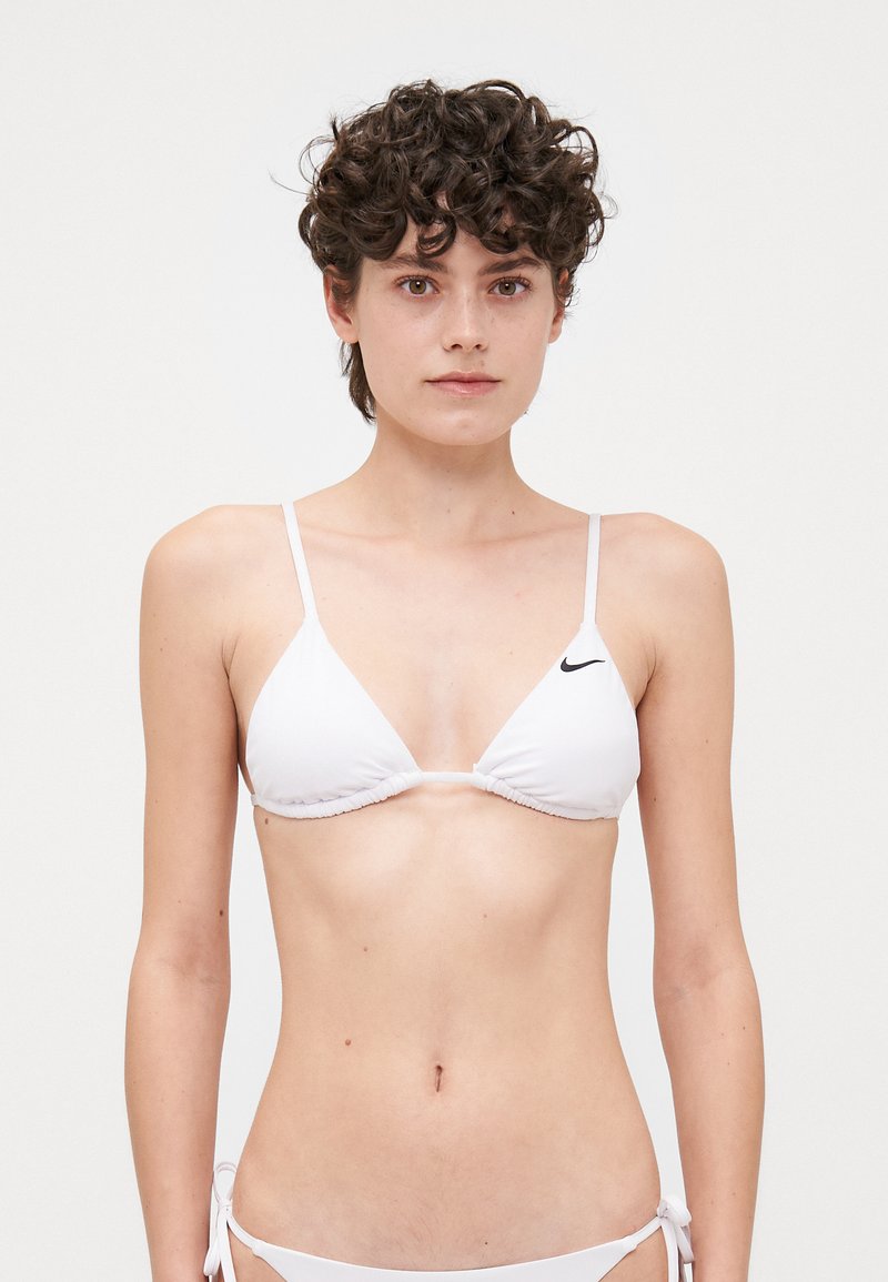 Biela bikiny s trojuholníkovými košíkmi a tenkými popruhmi. Obsahuje nariasenie a malé čierne logo Nike na ľavom košíku. Mäkká tkanina.