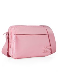 Bolso cruzado rosa con un exterior de nailon suave. Presenta un bolsillo frontal con cremallera, correa ajustable y un logo grabado en el lado.