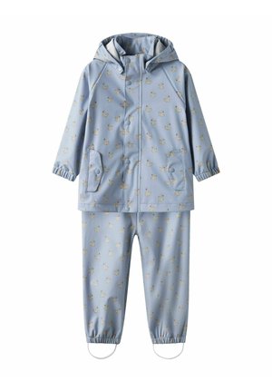 Jasnoniebieski skafander przeciwdeszczowy z kapturem, elastycznymi mankietami i wzorami białych łabędzi. Zawiera kurtkę i dopasowane spodnie z elastycznymi kostkami.
