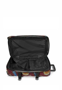 Valigia con un'esterno bordeaux decorato con patch a tema viaggio colorati; interno nero con scomparti e tasche con zip.