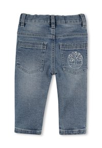 Jeans in denim di colore azzurro chiaro con taglio dritto, caratterizzati da una cintura elastica morbida e due tasche posteriori, una delle quali con un ricamo di design vegetale.