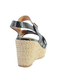 Zwarte neplederen wedge sandaal met gevlochten jute hak, enkelbandjes en een gestructureerde afwerking; ongeveer 7,5 cm hoog.