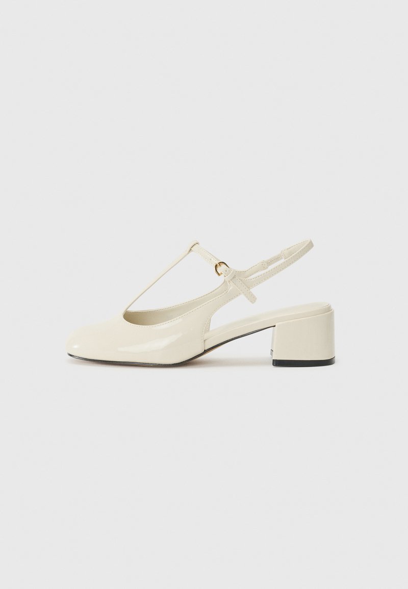 Beige lakovaný kožený slingback s kulatou špičkou, designem T-pásku a mohutným blokovým podpatkem s černým akcentem.