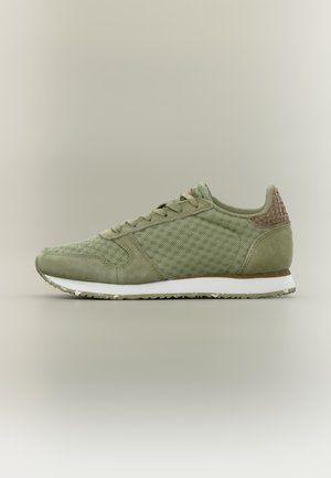 Olivgrüner Sneaker mit Mesh- und Wildleder-Obermaterial, braun strukturiertem Fersenakzent, weißer Zwischensohle und gemusterter Gummilaufsohle.