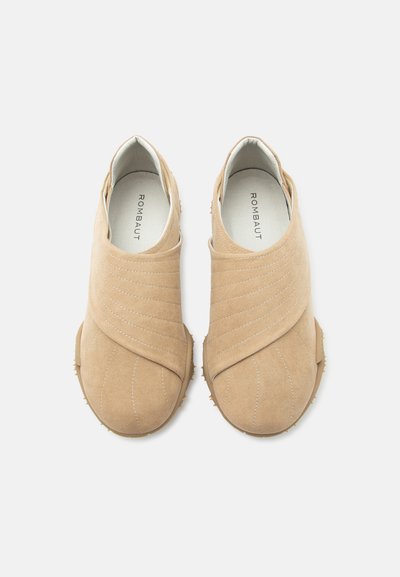 Ζευγάρι μπεζ σουέντ casual παπούτσια με καμπυλωτές ραφές και λαστιχένιες σόλες, σε θέαση από πάνω σε λευκό φόντο.