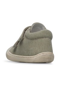 Scarpa slip-on in tela verde con punta arrotondata, superiore texturizzato e suola in gomma beige a contrasto. Presenta dettagli di cucitura minimi.