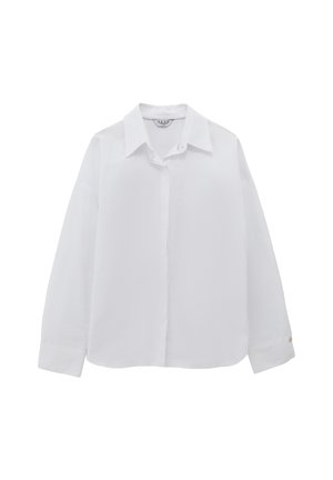 Camisa blanca de manga larga con cuello puntiagudo, frente abotonado y acento dorado en los puños. Tejido suave con un ajuste clásico y a medida.