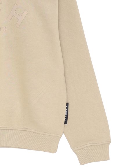 Felpa beige con finitura testurizzata, caratterizzata da un logo in rilievo e polsini a costine, insieme a un'etichetta nera sul lato.