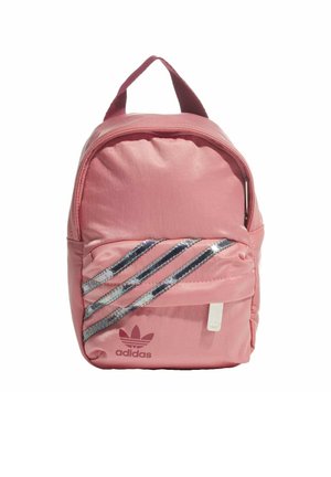 Petit sac à dos rose Adidas avec poche zippée à l’avant, trois bandes diagonales argentées réfléchissantes et poignée de transport supérieure.
