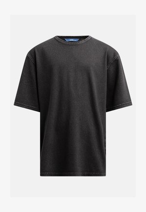 T-shirt de algodão preto com decote redondo, mangas curtas e detalhes de costura visíveis, apresentando uma forma relaxada e larga.