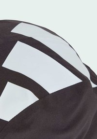 Black and white cap featuring bold geometric patterns. Fabric has a smooth texture with prominent white accents on an angled design.