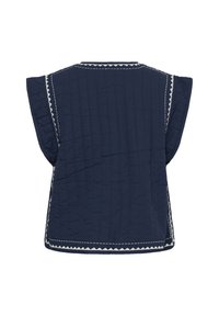 Top trapuntato blu navy con vestibilità rilassata, maniche corte a cappuccio e cuciture bianche a zigzag lungo i bordi. Tessuto strutturato con dettagli distintivi.