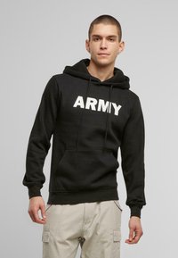 Fekete kapucnis pulóver, az elején hangsúlyos fehér "ARMY" nyomattal, puha anyagból készült, elülső zsebbel és húzózsinórral ellátott kapucnival.