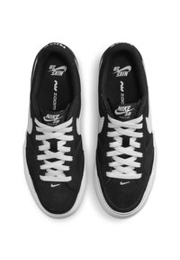 Fekete velúr gördeszkás cipők fehér fűzőkkel és fehér Swoosh logóval, párnázott bokarésszel és texturált talppal.