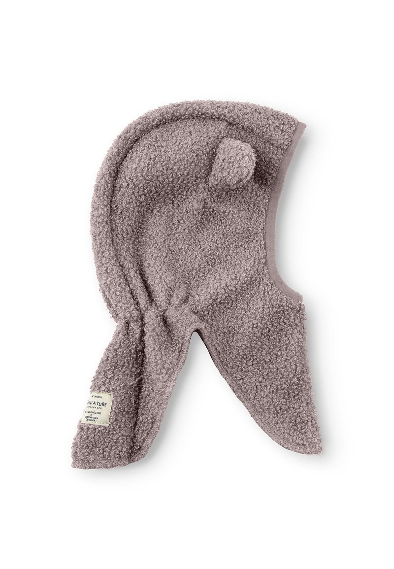 Chapeau en polaire marron clair avec un sommet arrondi, des rabats d'oreilles et un petit pompon. Présente une surface texturée et une étiquette en tissu sur le côté.