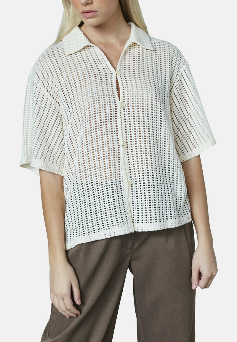 Hvid, semi-gennemsigtig skjorte med knapper, med et tekstureret vævet mønster, korte ærmer og en krave. Iøjnefaldende frontknaplukning med en afslappet pasform.