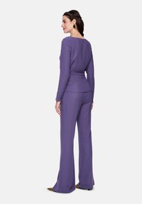 Purple knit top with a wide neckline paired with matching flared trousers. The fabric has a slight sheen and smooth texture.