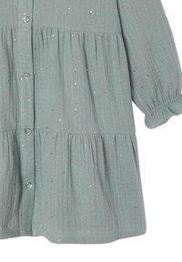 Hellgrünes Kleinkind-Kleid mit langen Ärmeln, rosa Pünktchen, Knopfverschluss vorne, elastischen Rüschenbündchen und gestuftem Rockdesign.