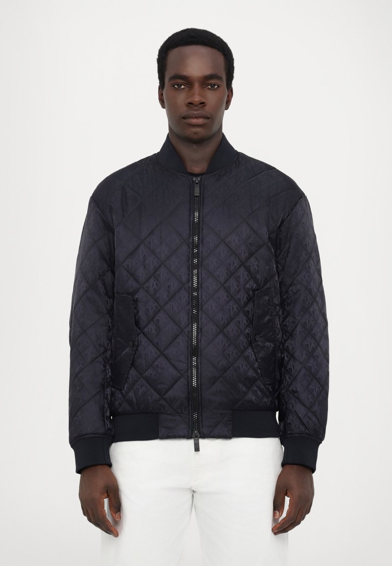 Quilted navy bomberjakke med lynlås, ribbede manchetter og sidelommer, der har et struktureret geometrisk mønster.