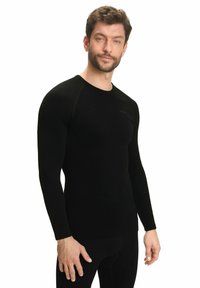 Zwarte langemouwen basislaag shirt met een ronde hals, aansluitend ontwerp en een soepele textuur. Heeft subtiele branding op de borst.