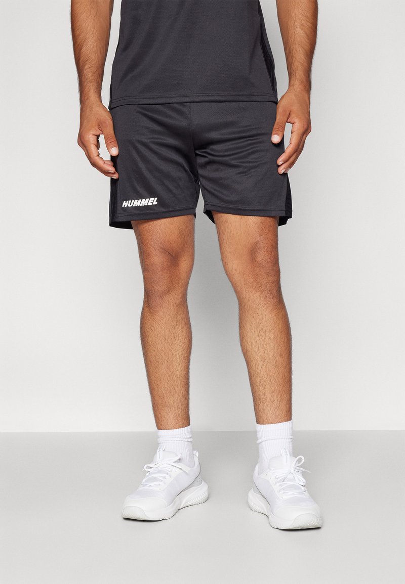 Zwarte sportshorts met het "HUMMEL" logo in het wit op het linkerbeen, gemaakt van een gladde, lichte stof met een elastische tailleband.